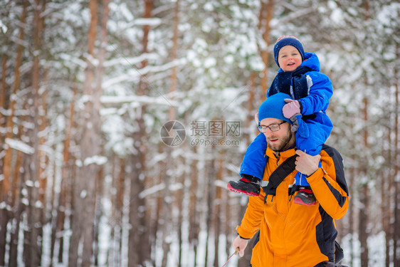 圣诞节衣服漫步冬天父亲带着年幼的孩子在树林里散步雪地橇和球中的冬季活动图片