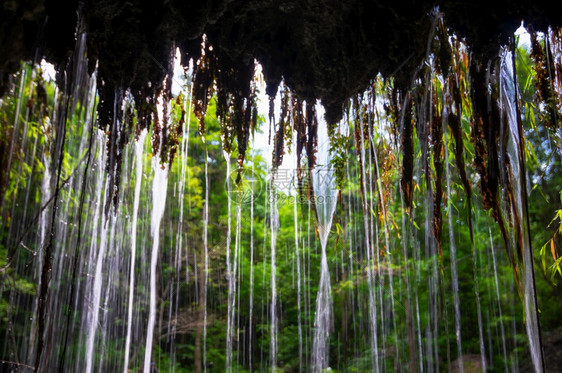 光滑的旅行PhaNamYod在泰国KaengkakchanPhetchaburi热带深森林中的瀑布从洞穴PhaYod瀑布内部的视图片