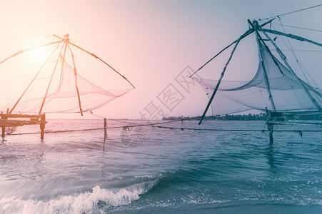 地标渔夫码头热带海滩的日落洋岸景观与渔网剪影在科钦南印度喀拉邦科钦图片