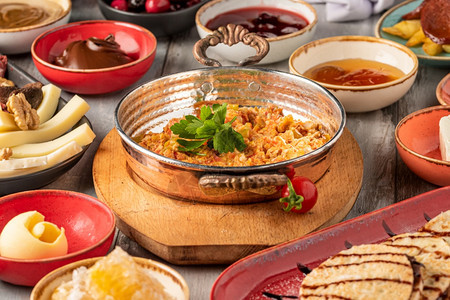 传统土耳其早餐在石桌上用传统的土制茶供应橄榄果酱汁图片