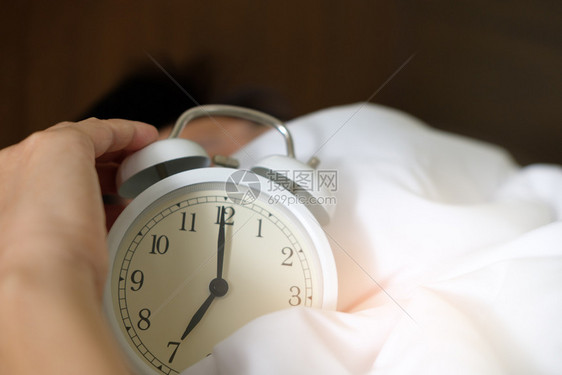 家毯子下的手伸到清晨闹钟上用浅橙色懒惰睡觉图片