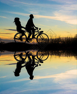 时间一对夫妇驾驶自行车的快乐时光日落闲暇活动图片