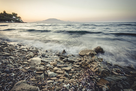 海滩景日落时在希腊Zakynthos的石滩上海浪支撑图片