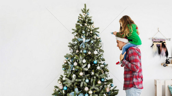 父亲帮女儿装饰圣诞树图片