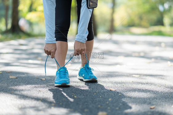 脚年轻运动员妇女在公园户外系鞋女运动员准备在外面的路上慢跑AsianFitness在早晨健康与体育概念中步行和徒锻炼AsianF图片