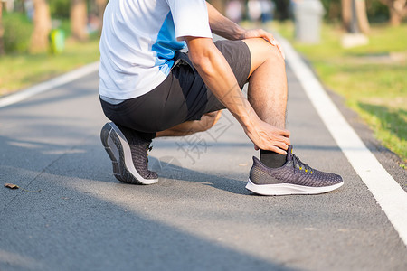 在训练亚裔运动员在上午和健康概念外跑步和锻炼后脚踝疼痛和问题时手持运动腿部受伤肌肉痛苦的年轻健身男子在训练亚裔跑者帕努瓦活动膝盖图片