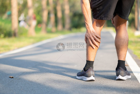 男人竞技在训练亚裔运动员在早晨和健康概念外跑步和锻炼后患上小牛腿痛和问题时手握运动腿部受伤肌肉疼痛的年轻健身壮男子公园图片