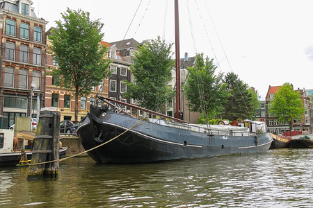 荷兰阿姆斯特丹2015年6月日在荷兰阿姆斯特丹一条运河上的船古老城市遗产图片