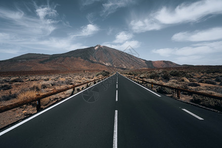 路线蓝色的多云天空下被山丘环绕的高速公路角度拍摄多云天空下被丘陵环绕的高速公路角度拍摄图片