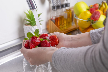 在厨房里洗草莓的妇女吃饭新鲜健康水果概念缝纫食物女士绿色图片