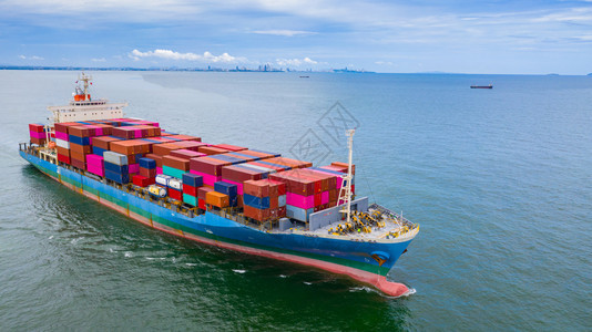 卸货新加坡在进口出业务物流和集装箱船舶在公海上国际运输方面载集装箱的船空中观视集装箱船在进出口业务中的国际运输航海图片