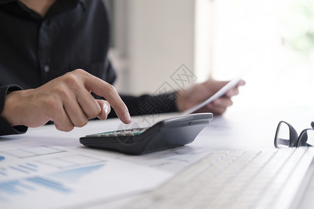 抵押商业会计概念使用算机膝上型电脑预算和办公室借纸计算器的商行员账单资产图片
