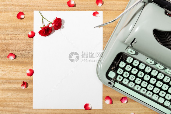 信爱嘲笑带空白纸复写打字机红玫瑰和花瓣的情书桌图片