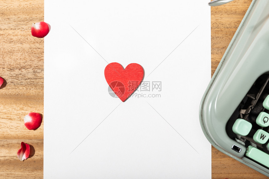 经典的带空白纸复写打字机和红心爱概念的情书桌优质花瓣图片