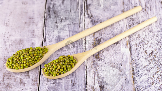 团体在旧木桌上用勺子汤匙中的蒙大豆在旧木桌上用勺子蒙大豆饮食白色的图片