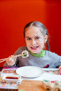 一顿饭盘子鱼小女孩在餐馆吃寿司孩子们在餐馆等食物小姑娘在餐厅吃寿司小女儿在餐馆吃寿司图片