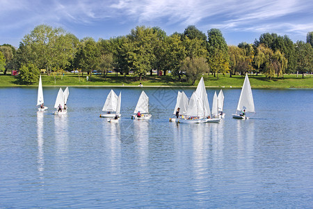 水手运输自然小型帆船在蓝湖上重渡图片