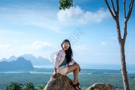 徒步旅行景观坐在泰国SamedNangChee的PhangNgaBay山顶上的年轻女子人们图片