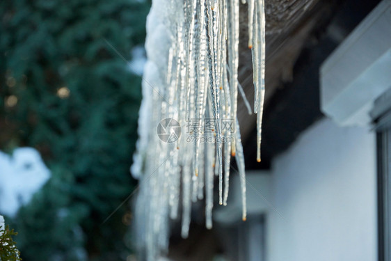 户外冰柱从雪花屋顶上挂下来水闪光图片