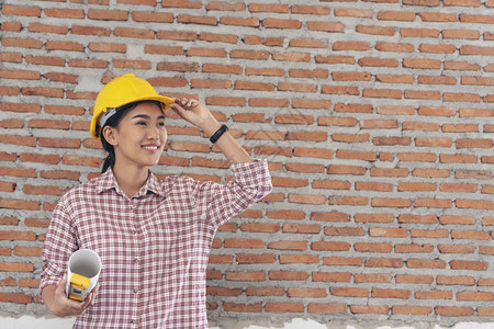 承包商女建筑工程师在地身戴安全白色钢帽的建筑工场薪女程师土木带有硬帽子安全头盔的女建筑工程师概念a妇女建筑工程师训练商业图片