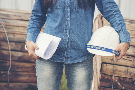 作坊行业金属丝女建筑工程师在地身戴安全白色钢帽的建筑工场薪女程师土木带有硬帽子安全头盔的女建筑工程师概念a妇女建筑工程师图片
