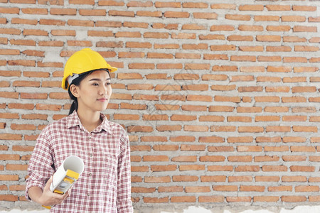 民事制造业格子女建筑工程师在地身戴安全白色钢帽的建筑工场薪女程师土木带有硬帽子安全头盔的女建筑工程师概念a妇女建筑工程师图片
