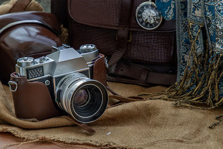 目的职业一个古老照相摄影机和一个棕色皮袋背着刀疤和小草布背景的口袋手表假日旅行概念设计复古的图片