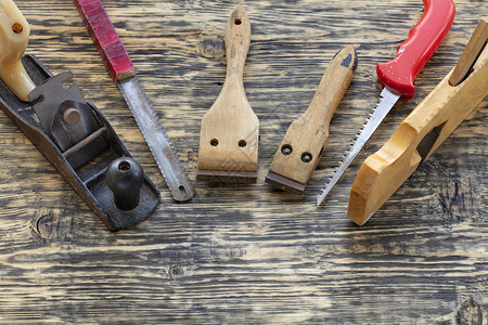 旧木工具刨子手锯和自行车放在木桌上旧工具放在桌上基辅劳动过时的图片