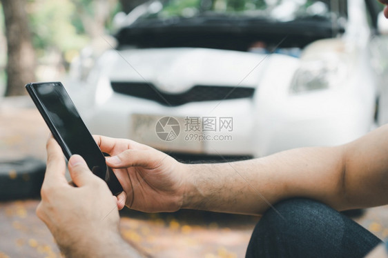 亚洲男子在街头汽车故障后使用智能手机获得援助车辆发动机问题概念或事故以及专业技工的紧急帮助亚洲男子利用智能电话获得援助使固定交通图片