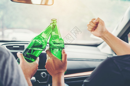 危险的保非法醉酒男人和朋友的派对开车在路上拿着瓶啤酒危险醉驾车概念图片