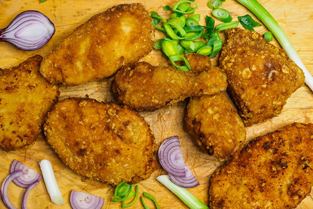 油炸鸡肉排切餐板上的炸鸡肉桂条土制的面包薯条工作室小吃图片