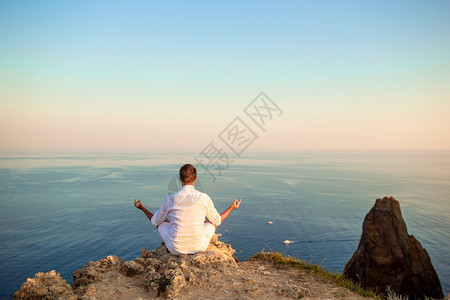 在悬崖边缘的白色户外男人享受山顶岩石的景色在悬崖海岸边缘的野外男人闲暇喜悦海滨图片