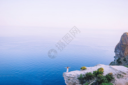 穿着白裙子的快乐女孩在山度假悬崖海岸边缘露天旅游女客探索高的人们图片