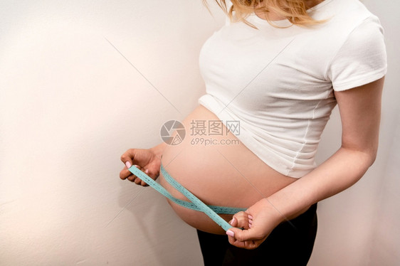 妈孕妇的美丽身体带卷尺母亲在家中检查未出生婴儿的发育保健和康怀孕生活方式期待的内部图片