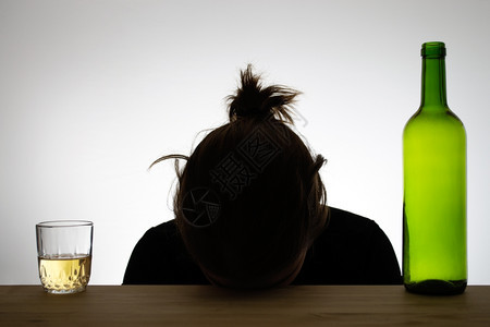 挫折酒瓶和一杯红用瓶和杯将精女人的配额摇在周光中独自的一种图片