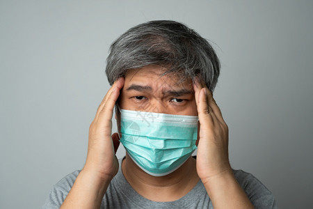 抓住精神的痰身戴医疗面罩的亚洲病男子用手将头的痛抓在部保护大流行冠状和呼吸道疾概念图片