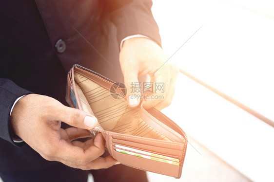 货币女士在购物时看着钱包的不快乐年轻人肖像财富图片