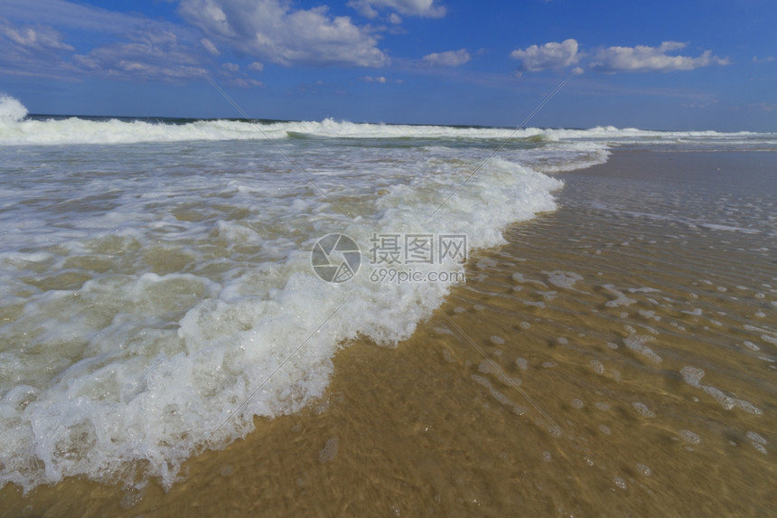 美丽的支撑大西洋海滩的浪冲天空图片