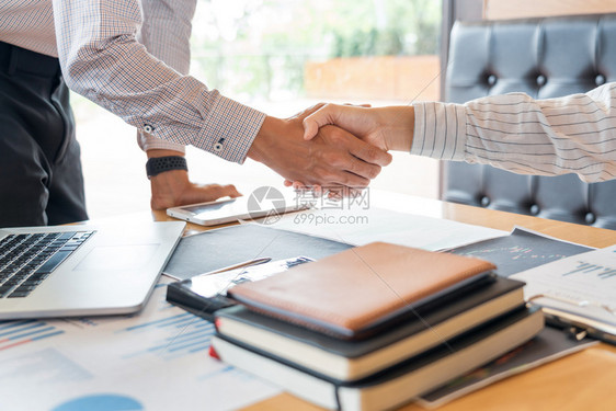 握手概念在完成交易项目或就办公室背景进行谈判时成功后保持手握或者以办公室背景为谈判的讨价还合同事工作图片