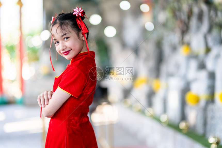 身着中华新年节国青春红传统香藏装饰的可爱亚洲小女孩长得一脸美丽的笑并戴着彩礼庆祝旅行红色的图片