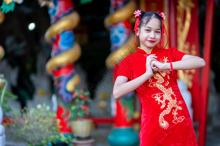 乐趣神社可爱的身着中华新年节国青春红传统香藏装饰的可爱亚洲小女孩长得一脸美丽的笑并戴着彩礼图片