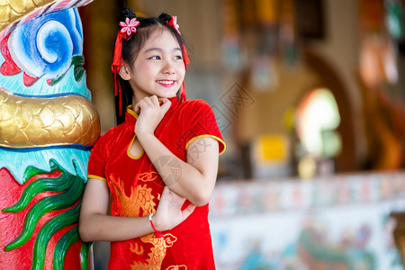 身着中华新年节国青春红传统香藏装饰的可爱亚洲小女孩长得一脸美丽的笑并戴着彩礼宗教淑女可爱的图片