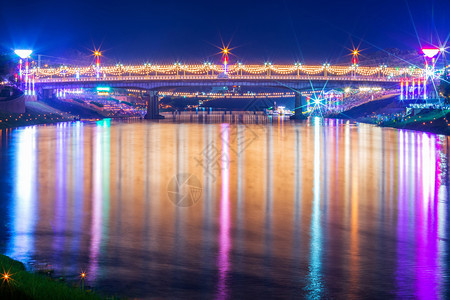 屋丰富多彩的蓝色南河上美丽光芒晚上在纳里苏大桥的Naresuan桥上白天在泰国菲特桑卢克市LoyKrathong节图片