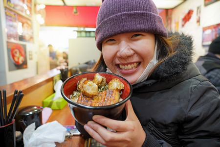 哪一个午餐女孩亚洲年轻享受日本菜美食在鱼市东京日本的碗里有大米和虾图片