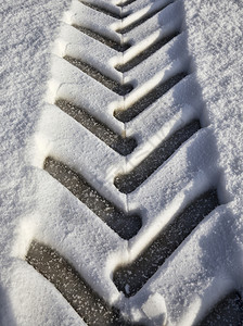 黑色的踪迹冷冻下雪后新中拖拉机的痕迹胎面技术的结构和痕迹细节拖拉机特写痕迹图片