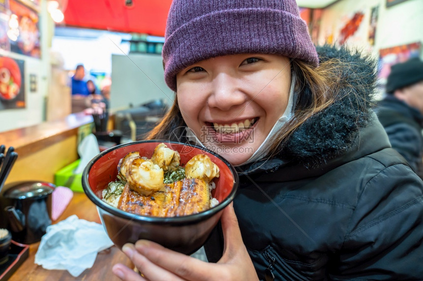 寿司美丽的保持亚洲年轻女享受日本菜美食在鱼市东京日本的碗里有大米和虾图片