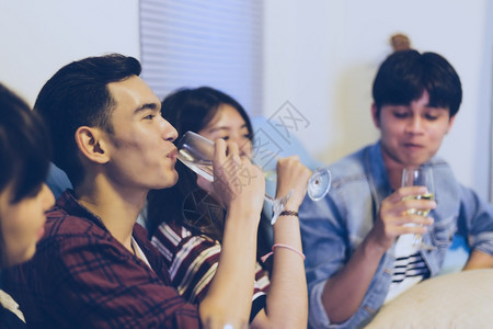 女亚洲朋友团体与有聚会酒精啤饮料和年轻人享受在酒吧敬鸡尾软糖的焦点吃男图片