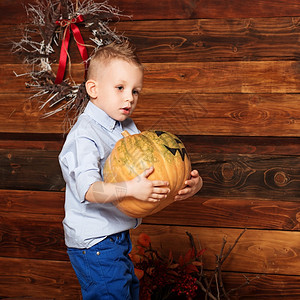 婴儿领带糟糕的小可爱男孩在万圣节装饰中玩得开心和孩子一起拿着涂重南瓜的万圣节派对图片