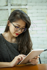 内容更年轻在计算机平板电脑上读信息的女年青亚洲健康图片