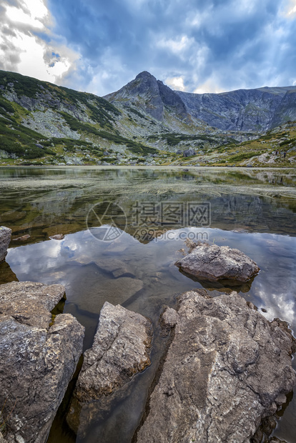 寒意高山绿色湖上的美日风景在前垂直视图处有岩石的山湖图片